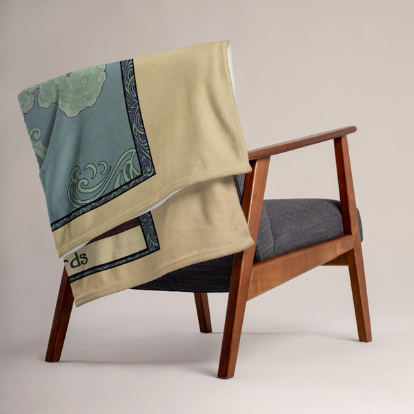 The Ace of Swords blanket folded and draped over the back of a chair.