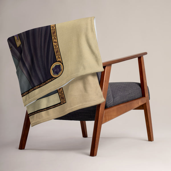 A blanket folded and draped over the back of a chair.