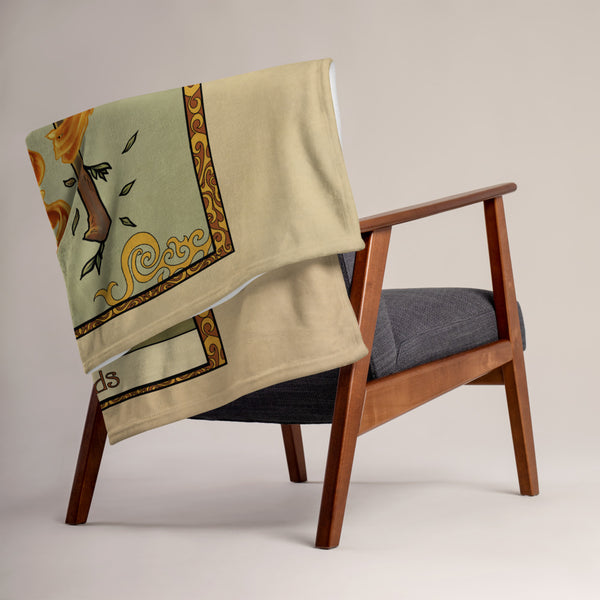 The Ace of Wands blanket folded and draped over the back of a chair.