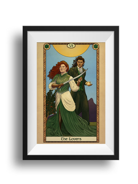 A framed print of a woman and man standing beneath a bright sun. The woman holds her sword ready, smiling back at the man who is casting a spell. The art is surrounded by a decorative border with the words "The Lovers" at the bottom.